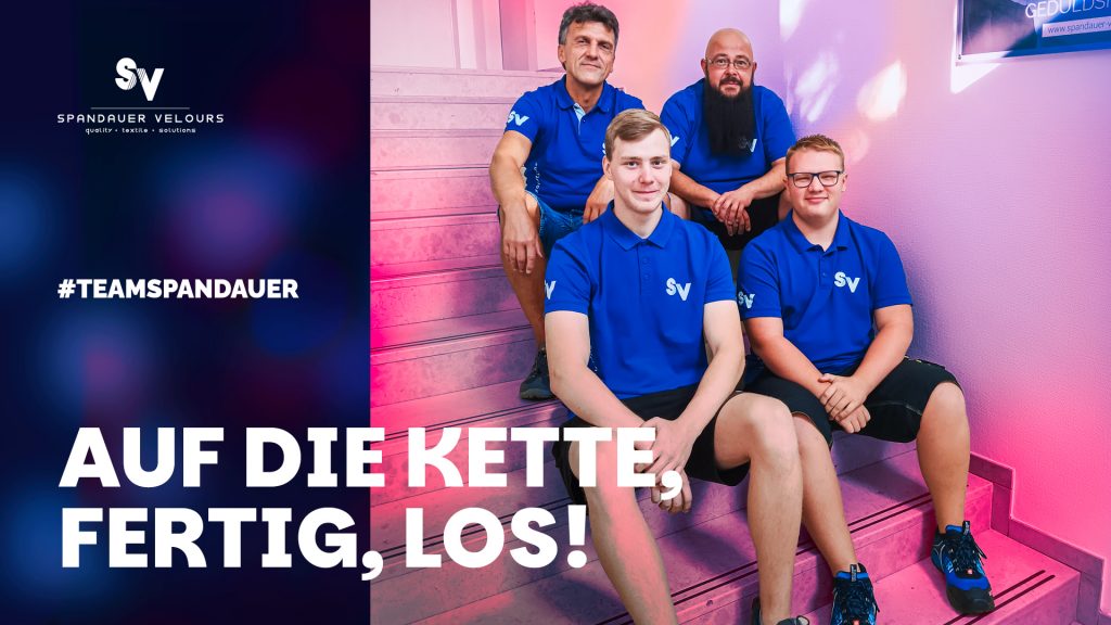 2 neue Azubis auf einer treppe sitzend, dahinter sitzen die beiden Ausbilder
