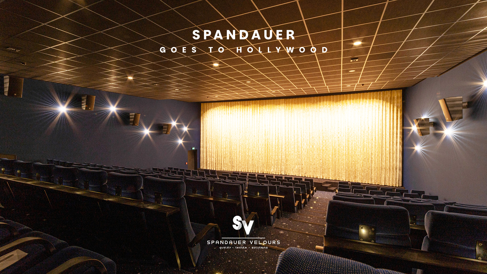 Moderner Kinosaal mit blauen Samtsitzen und goldenem Bühnenvorhang von Spandauer Velours unter dem Motto Spandauer goes to Hollywood.