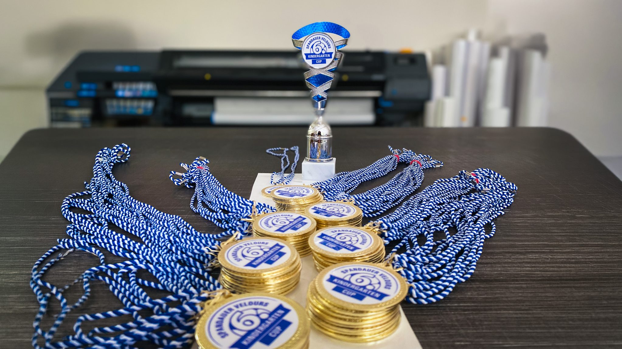 Tisch mit Vielen Medaillen und einem Pokal für den 6. Spandauer Velours Kita Cup