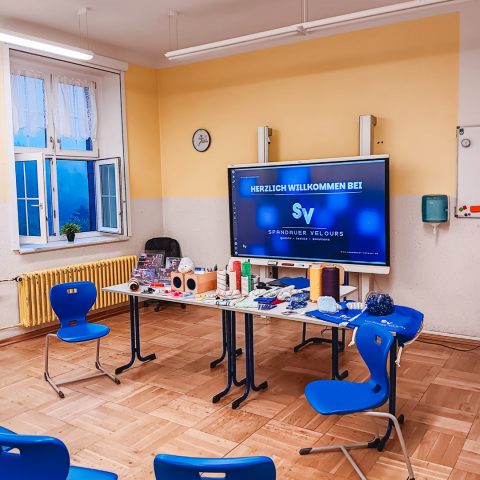 Klassenzimmer in der Oberschule Hartenstein mit blauen Stühlen, Digital-Whiteboard und Infomaterialien für das Bewerbertraining der Spandauer Velours.