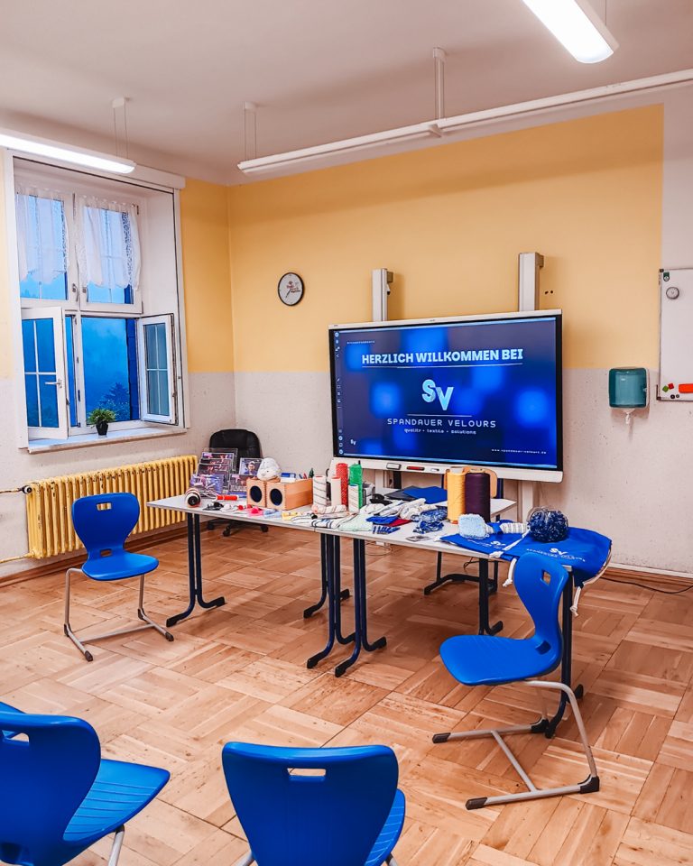 Klassenzimmer in der Oberschule Hartenstein mit blauen Stühlen, Digital-Whiteboard und Infomaterialien für das Bewerbertraining der Spandauer Velours.