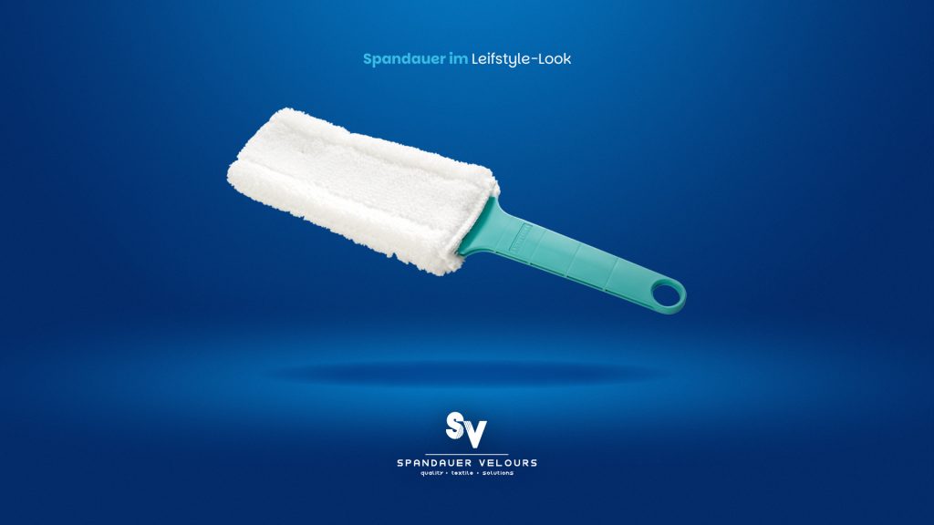 Türkiser Staubwedel mit weißem Veloursbezug schwebt vor blauem Hintergrund. Darüber steht „Spandauer im Lifestyle-Look“, darunter das Logo von Spandauer Velours.